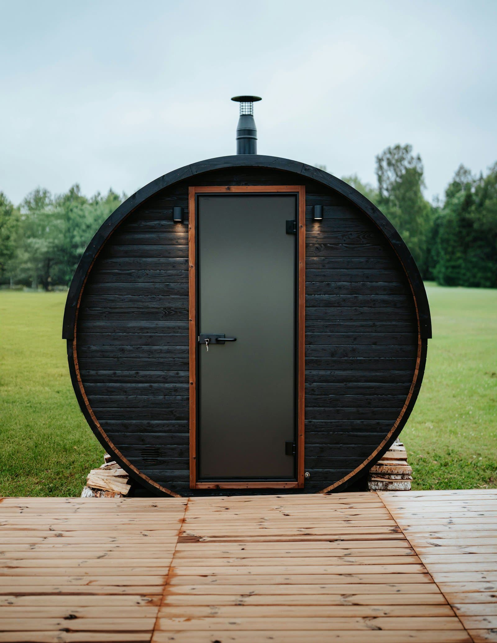 A backyard barrel sauna on a wooden deck